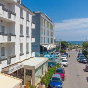 een uitzicht op een hotel met auto's geparkeerd op straat bij Hotel San Marino in Riccione