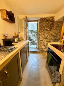 cocina con fogones y pared de piedra en Cap Hélios, Centuri, en Morsiglia