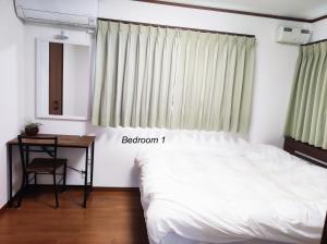 御殿場市にある駅近4分 富士山を眺める和風宿2のベッドと机と窓のある寝室