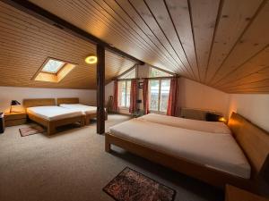a bedroom with two beds and a ceiling at Chalet Maithili Lauterbrunnen -152-Year-Old Majestic Chalet in Lauterbrunnen