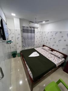 AR lodge في تيروفانمالي: غرفة نوم بها سرير وتلفزيون