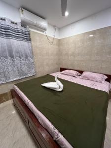 AR lodge في تيروفانمالي: غرفة نوم مع سرير كبير مع مروحة