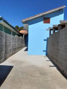 een blauwe deur aan de zijkant van een bakstenen muur bij Casa independente e aconchegante in Poços de Caldas