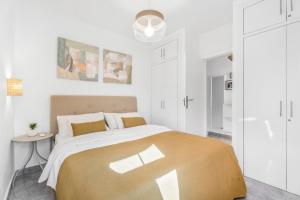 een witte slaapkamer met een groot bed en een tafel bij Yucca Park 1 Bed Apartment in Adeje +20 foto's