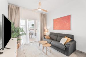 een woonkamer met een bank en een tafel bij Yucca Park 1 Bed Apartment in Adeje