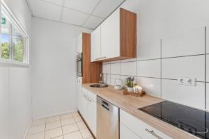 a kitchen with white cabinets and a sink at For Workers Bedburg Hau in Bedburg Hau