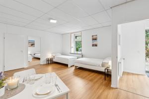 a white living room with a table and a bed at For Workers Bedburg Hau in Bedburg Hau