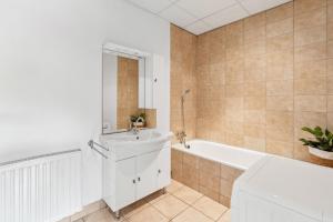 a white bathroom with a tub and a sink at For Workers Bedburg Hau in Bedburg Hau +7 photos
