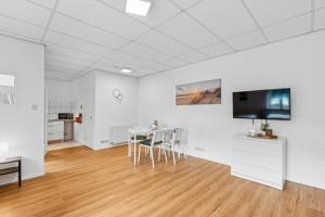 a white room with a table and a tv on a wall at For Workers Bedburg Hau in Bedburg Hau