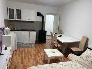 a kitchen and a living room with a table and chairs at Apartman Ivano Kupres in Kupres