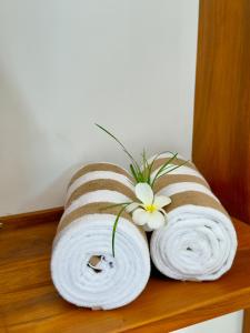 タンガラにあるSouthern Nest Villa Tangalleの木製の棚の上に巻かれたタオルが数枚と花が飾られている