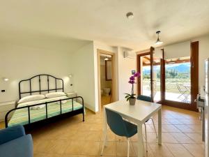 Un dormitorio con una cama y una mesa y sillas. en Cronta Apartments, en Bari Sardo