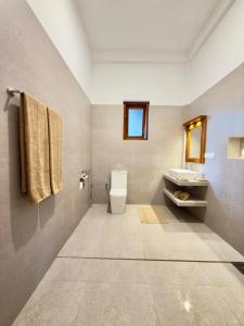 タンガラにあるSouthern Nest Villa Tangalleのトイレと洗面台のあるバスルーム