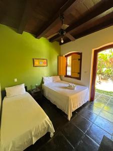 two beds in a room with green walls at Pousada Solar do Algarve in Paraty