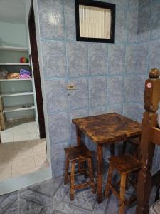 Zimmer mit einem Holztisch und 2 Hockern in der Unterkunft loft anagro 103 in Ubatuba