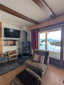 a living room with a couch and a tv at Appartement-chalet à Verbier près des pistes in Verbier