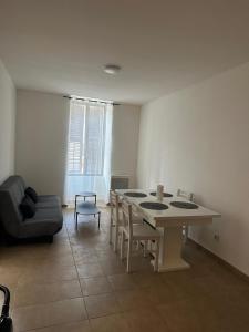 a living room with a table and chairs and a couch at Beau T3 in Aiguebelle +4 photos