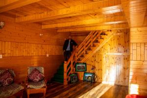 Un hombre de pie en las escaleras de una cabaña. en Palach Kothi, en Banjār