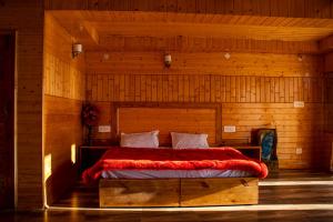 Un dormitorio con una cama en una habitación de madera. en Palach Kothi, en Banjār