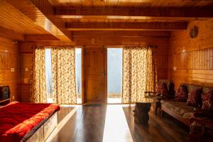 Un dormitorio con una cama y un sofá y ventanas. en Palach Kothi, en Banjār