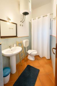 a bathroom with a sink and a toilet and a mirror at Salina Castel Vinci in Rinella