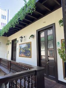 a house with a balcony with a door and ivy at Ancestral Lima Downtown in Lima