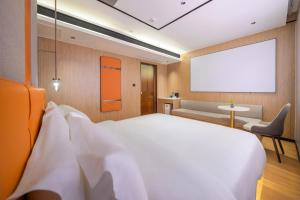 Un dormitorio con una cama blanca grande y una pantalla en blanco. en Guilin Meiju Lishui Hotel, en Yangshuo 10 fotos más
