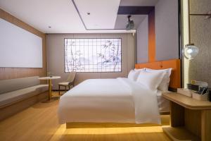 Un dormitorio con una cama blanca grande y una ventana en Guilin Meiju Lishui Hotel, en Yangshuo