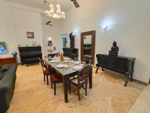 een woonkamer met een tafel en een piano bij Villa Portuguesa 5 bhk calangute in Calangute
