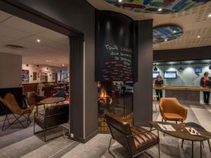 沃伊皮宜必思梅斯北欧酒店的一家餐厅，里面有桌椅，墙上贴着菜单。