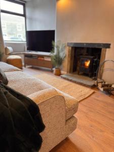 ein Wohnzimmer mit Couch und Kamin in der Unterkunft La Casa De Campo - Dog Friendly Cottage in Long Preston
