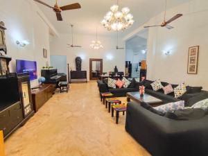 een woonkamer met banken en een flatscreen-tv bij Villa Portuguesa 5 bhk calangute in Calangute