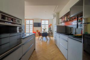 a large kitchen with stainless steel appliances and wooden floors at Duplex coloré 6 personnes Place des Héros - vue Beffroi - Centre ville in Arras