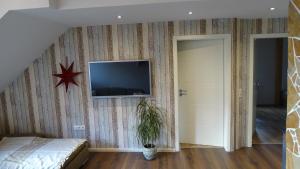 a bedroom with a bed and a tv on a wall at Overlinger Gästehaus in Westoverledingen +3 photos