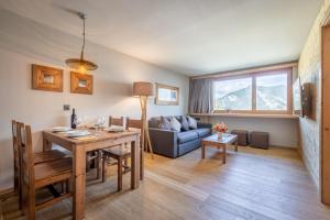 a living room with a table and a couch at SWISSPEAK Resorts Vercorin in Vercorin