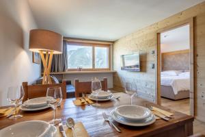 a dining room with a wooden table with plates and wine glasses at SWISSPEAK Resorts Vercorin in Vercorin +38 photos