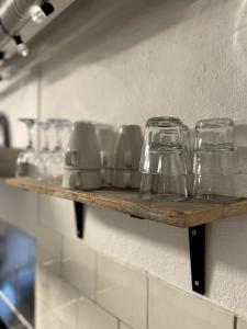 three glasses on a shelf in a kitchen at Charming apartment with industrial design close to city center in Växjö