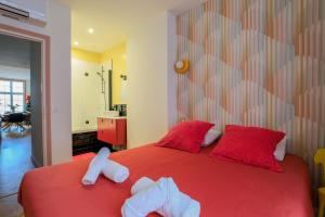 a bedroom with two stuffed animals on a red bed at Duplex coloré 6 personnes Place des Héros - vue Beffroi - Centre ville in Arras