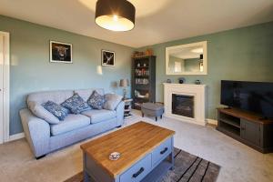 a living room with a couch and a fireplace at Host & Stay - Carterhouse in Jedburgh
