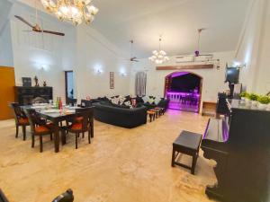 een woonkamer met een bank en een tafel bij Villa Portuguesa 5 bhk calangute in Calangute +11 foto's