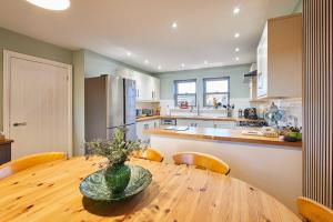 a kitchen with a wooden table with a vase on it at Host & Stay - Carterhouse in Jedburgh +18 photos