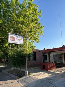 a sign on a pole in front of a building at Hostal Andino in Eugenio Bustos