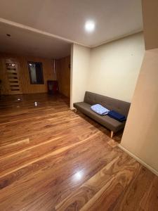 a living room with a couch and a wooden floor at Alojamiento casa in Temuco