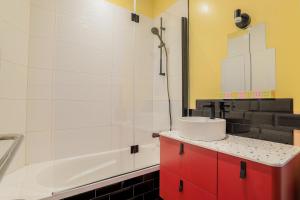 a bathroom with a sink and a bath tub at Duplex coloré 6 personnes Place des Héros - vue Beffroi - Centre ville in Arras +15 photos
