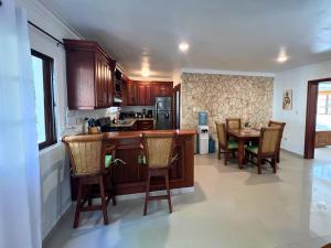 a kitchen with wooden cabinets and a table and chairs at Apartamento con Piscina 2 Habitaciones Cerca de la Playa Bavaro in Punta Cana