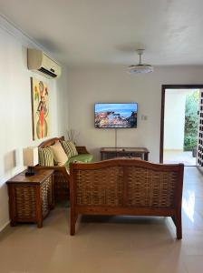 a living room with a couch and a tv on the wall at Apartamento con Piscina 2 Habitaciones Cerca de la Playa Bavaro in Punta Cana