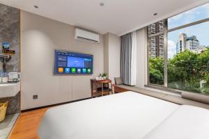 une chambre avec un grand lit et une grande fenêtre dans l'établissement Chami Apartment Hotel, Buhadi, à Canton