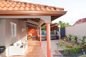 a patio with orange columns and a roof at Maison de vacance 2 Chambres à 200m de la plage in Sainte-Anne