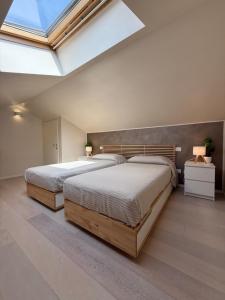 two beds in a bedroom with a skylight at Ca' Maiolo - Villa con piscina in Montecchio Maggiore +39 photos