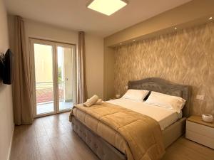 Un dormitorio con una cama y una ventana grande. en The Villas - Guest Houses, en Scafati